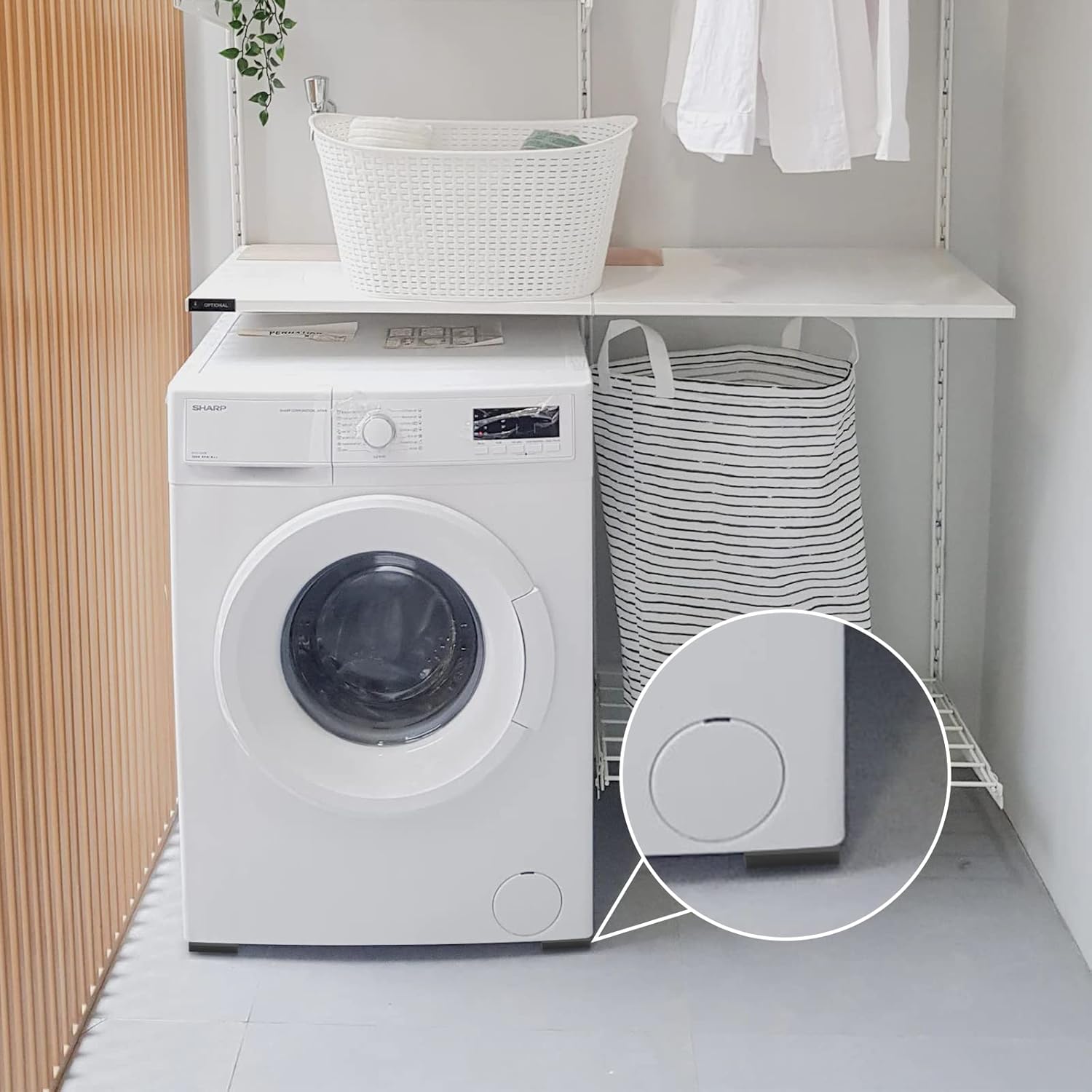 White washing machine on the round anti vibration pads in a laundry room with baskets and clothes.
