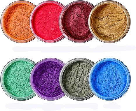 Set of eight small containers with colorful seisso mica powders in various colors on a white background