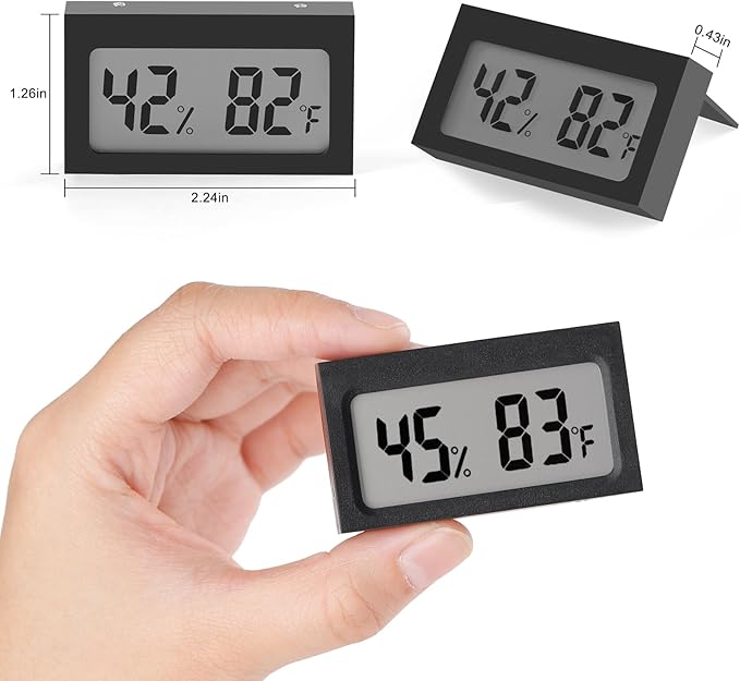 Digital thermometer with temperature and humidity display held by a hand, showing measurements on a white background.