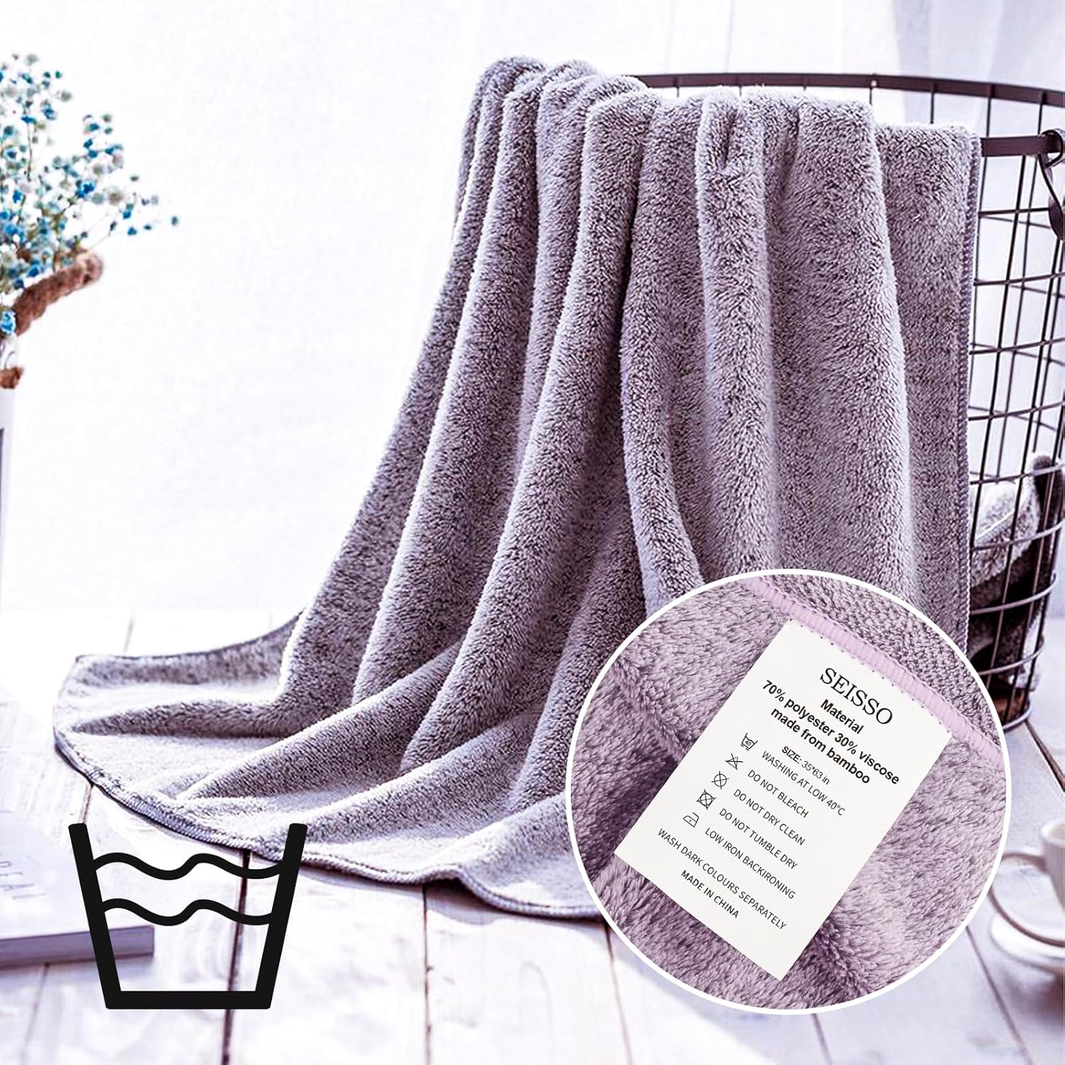 Seisso purple bath towel draped over a wire basket with a close-up of the brand label.